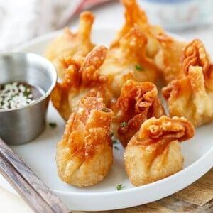 plate of crispy golden chicken wontons with dipping sauce