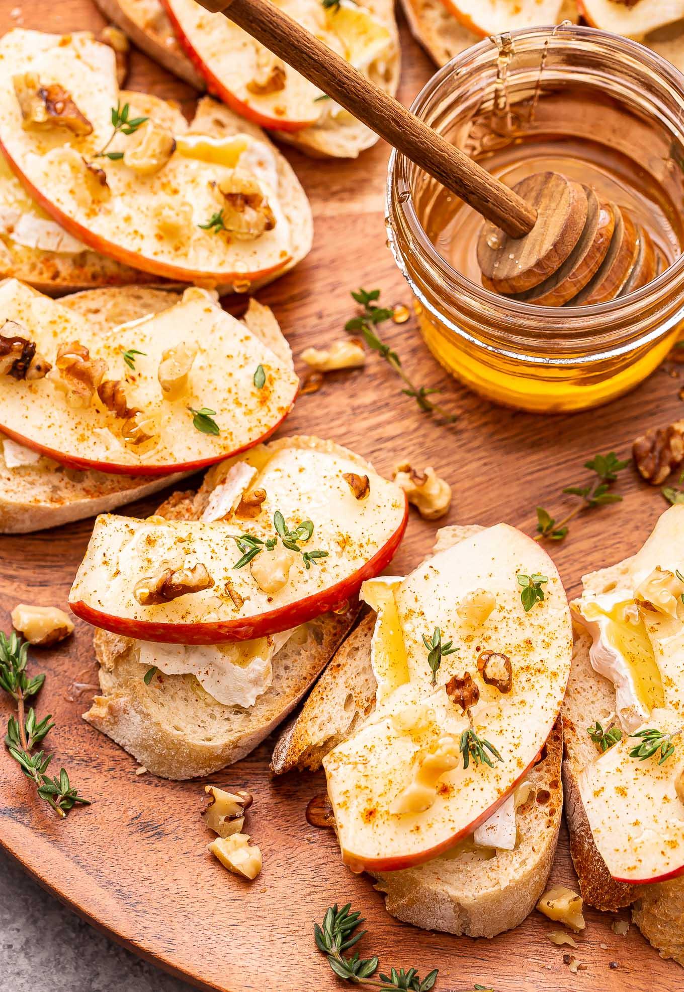 Brie Apple Chicken Parmesan Crostini served on a wooden board