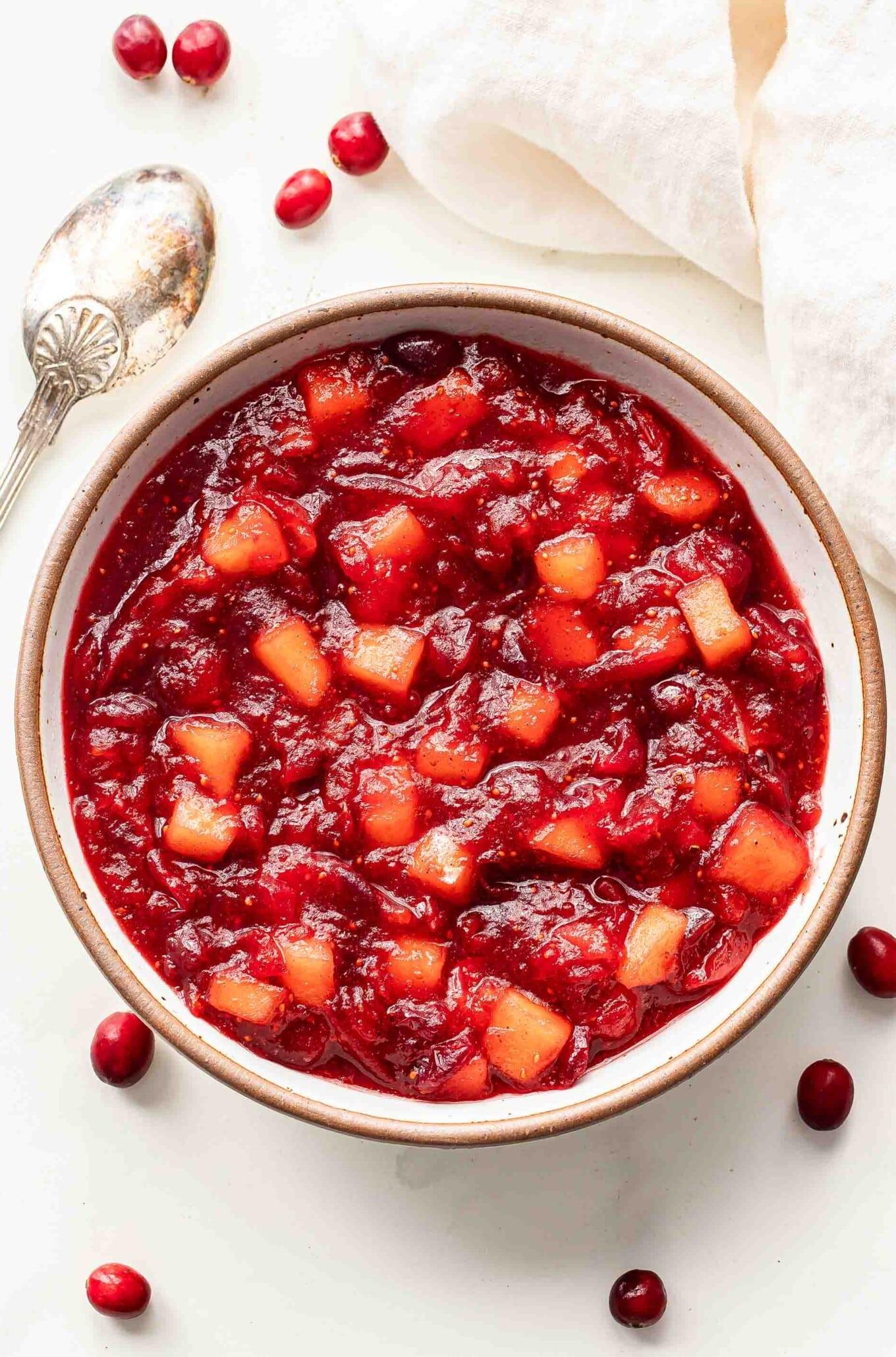 serving bowl of homemade cranberry apple sauce on a decorated holiday table