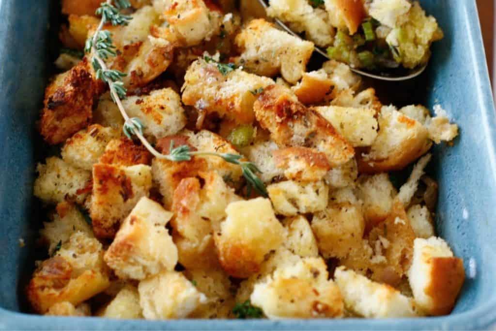 Close-up of golden brown stuffing with visible chunks of bread, herbs, and vegetables