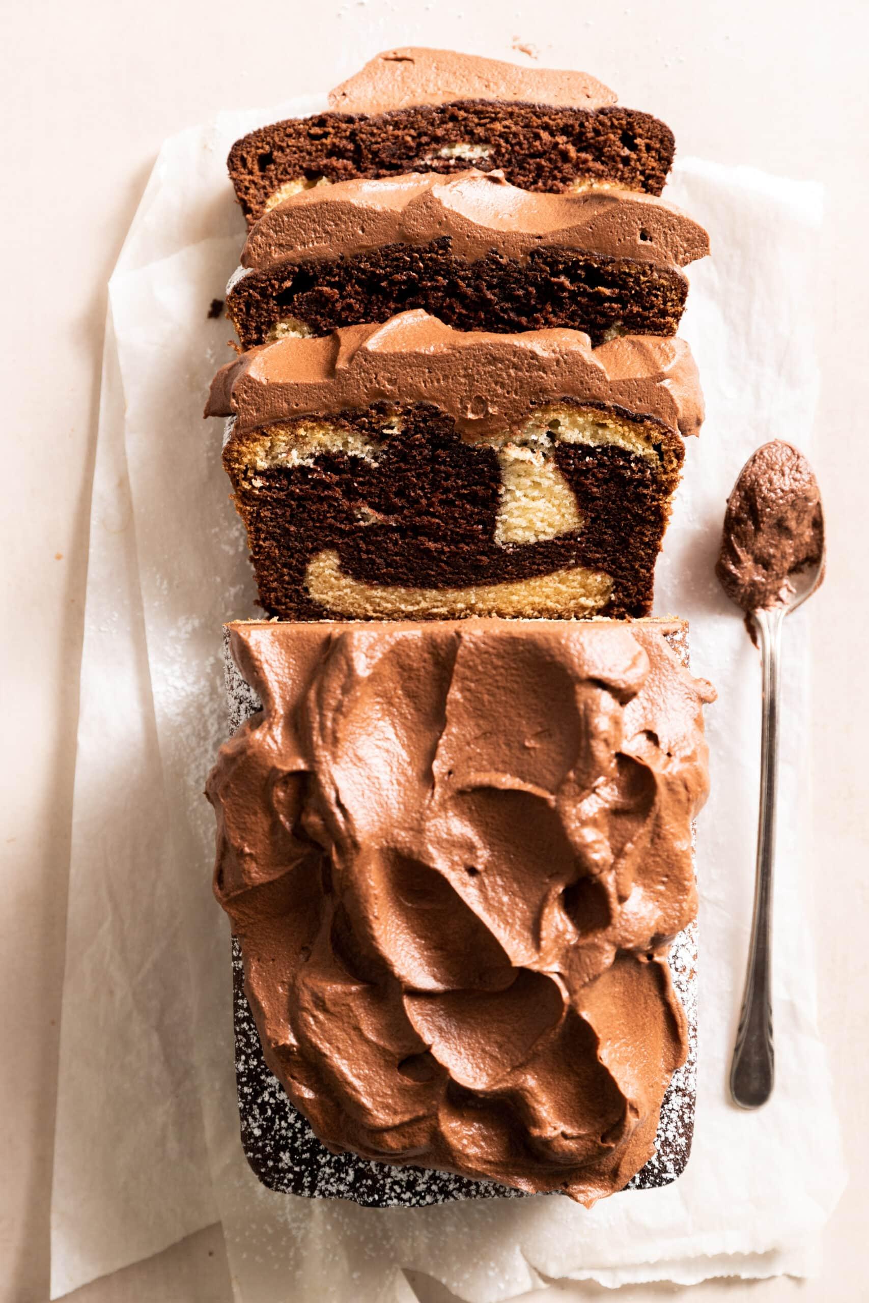 overhead shot of two cake layers being stacked with chocolate ganache