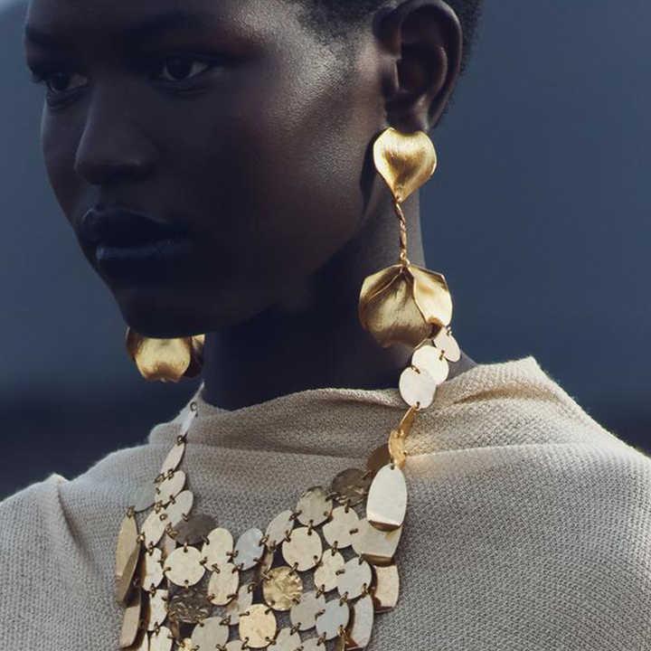 woman with statement earrings at an art gallery