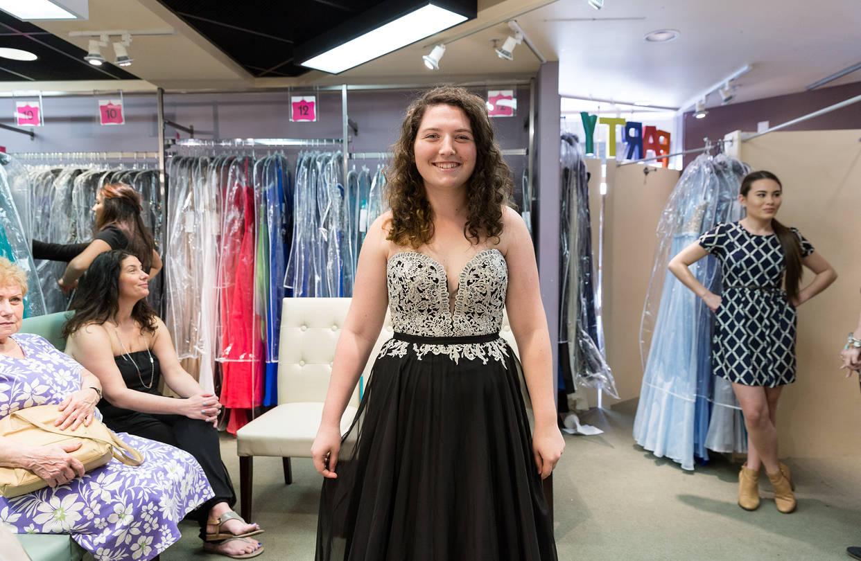 woman looking at prom dresses in a store