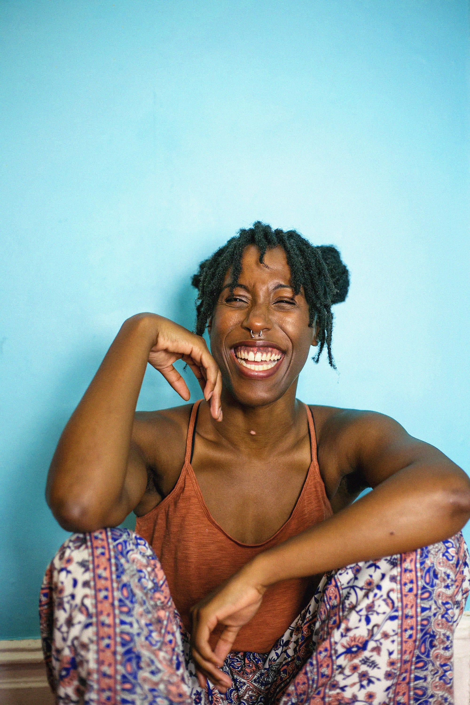 woman with short dreadlocks smiling confidently