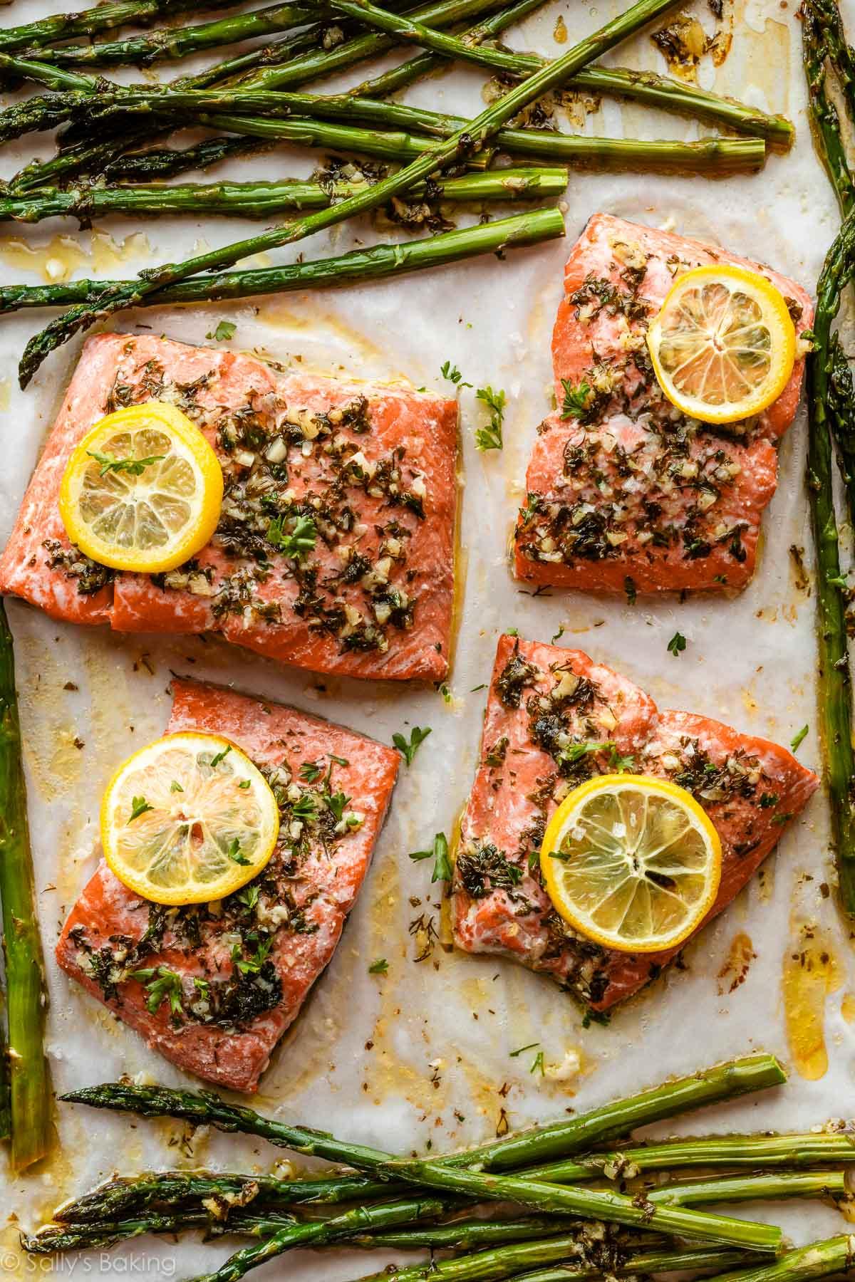 baked salmon with lemon and herbs on a baking sheet
