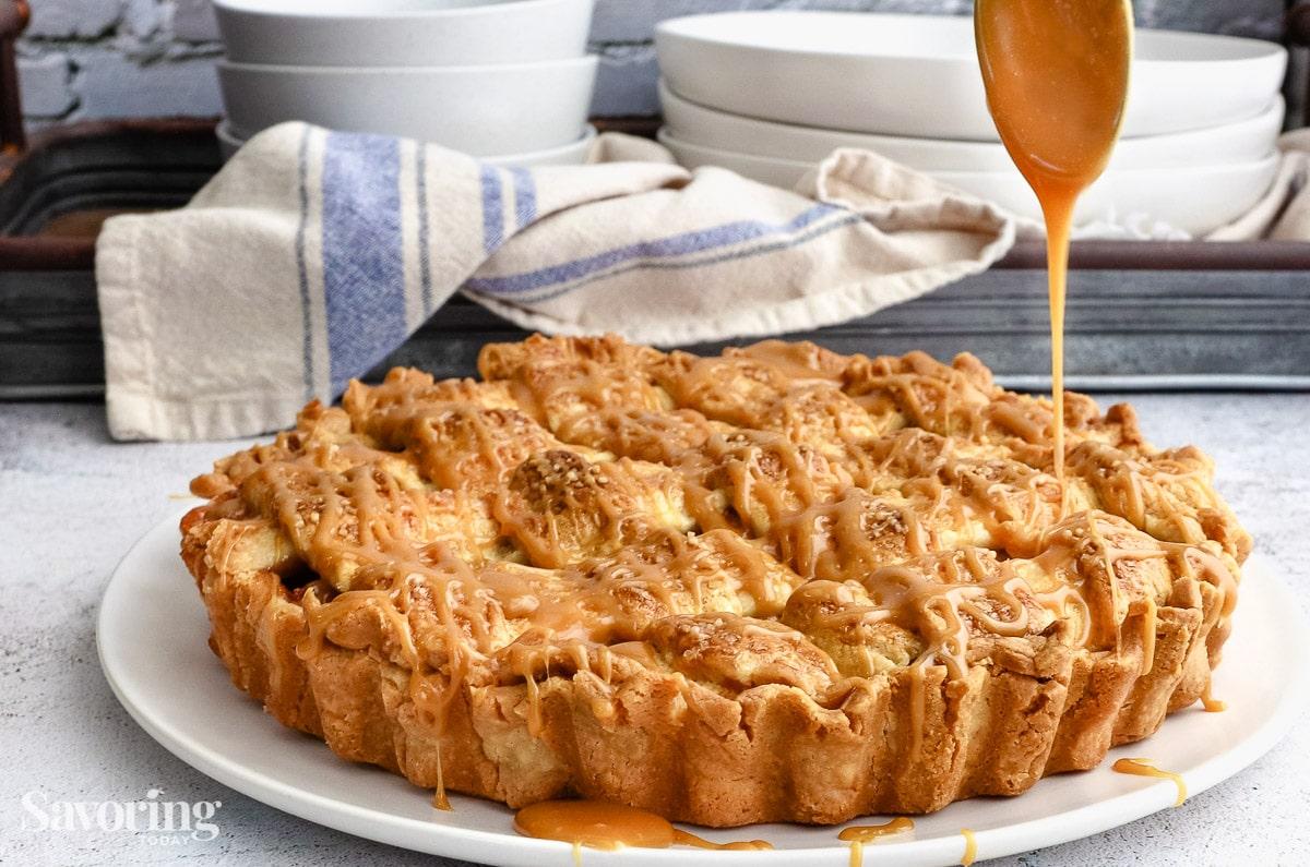 Baked caramel apple tart cooling on a wire rack, steam gently rising, golden brown crust