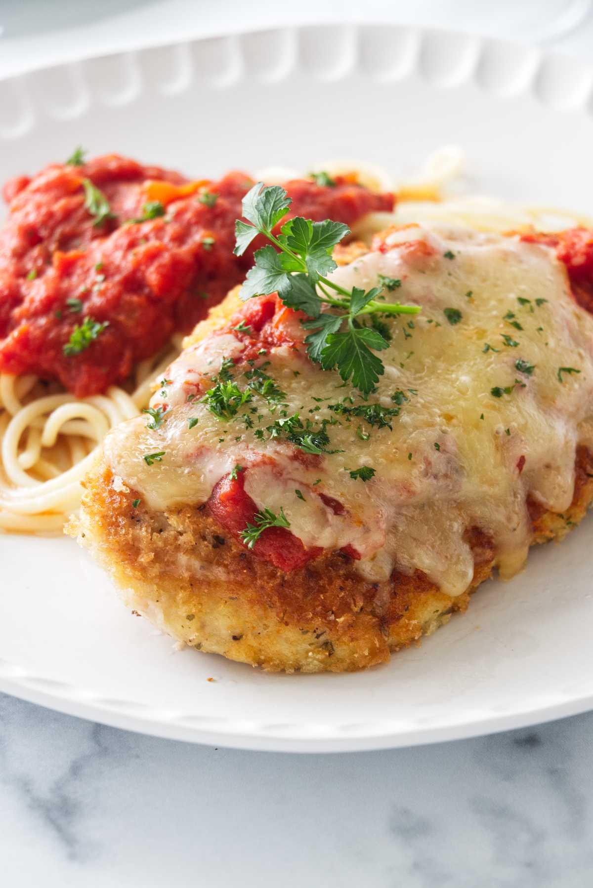 golden chicken parmesan fritters being dipped in marinara sauce
