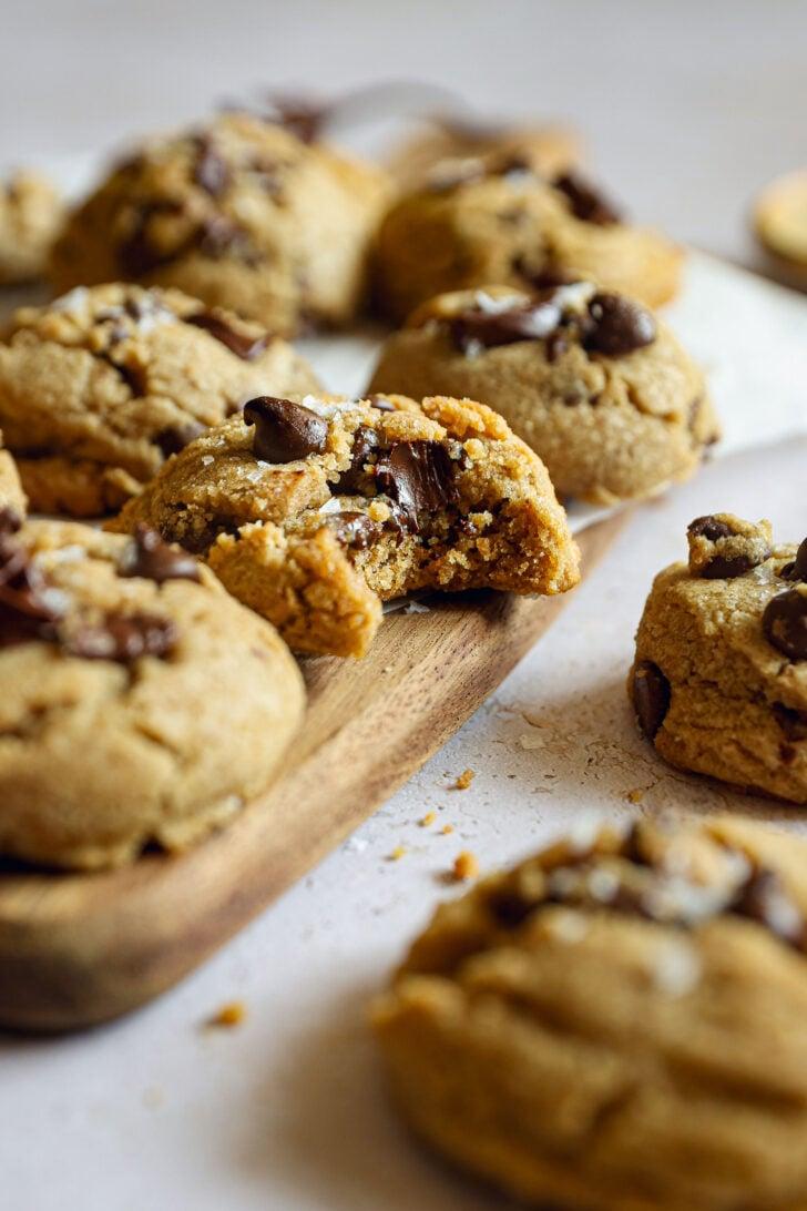 Close-up of warm, soft-centered chocolate chip cookie with melted chocolate chips, slightly broken to show gooey interior