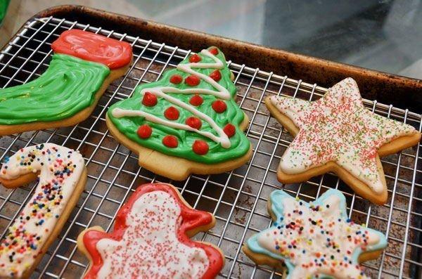 Close-up of baked sparkling sugar cutout cookies on a cooling rack, some with red and green sprinkles