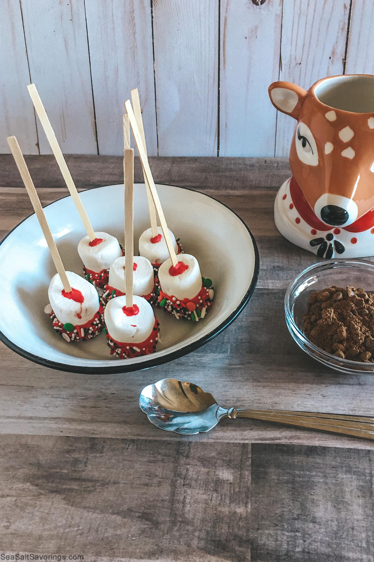 beautifully arranged chocolate-dipped marshmallows with sprinkles on a rustic wooden board
