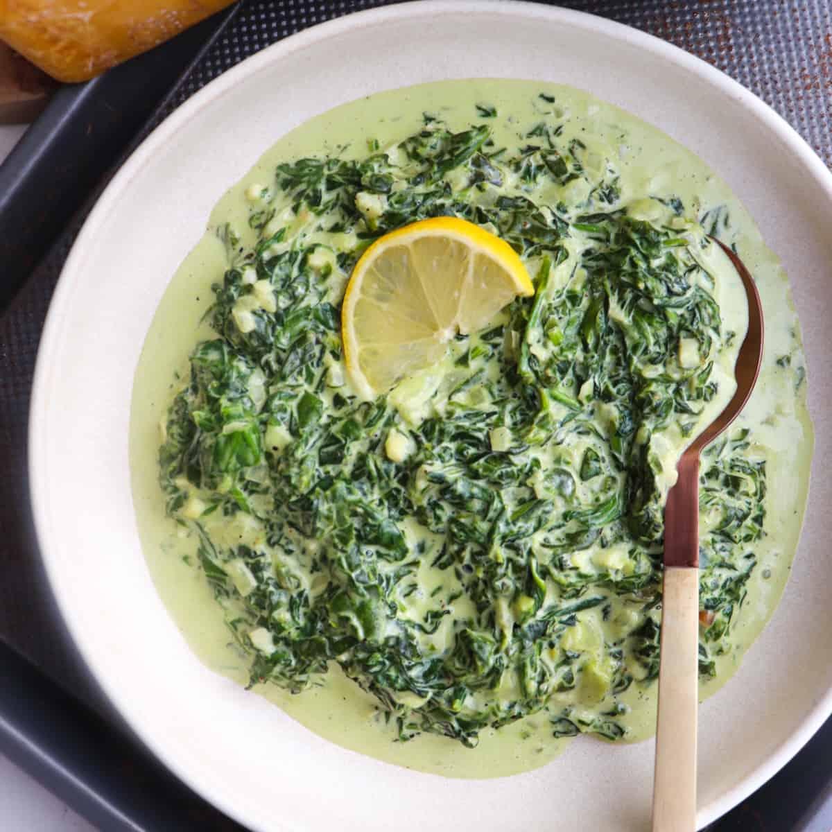 luscious bowl of creamed spinach with steam, cozy lighting