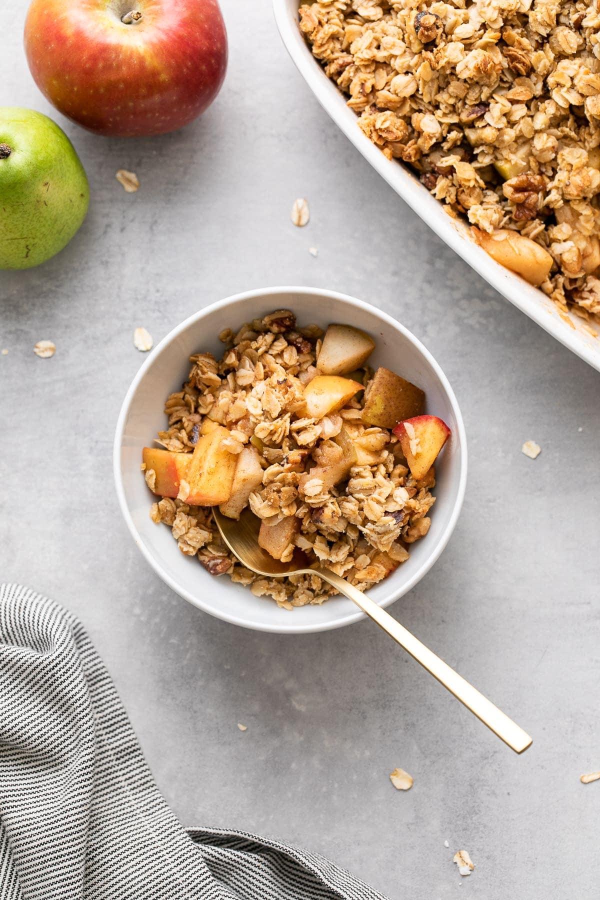 top-down view of a freshly baked pear crisp with a rustic wooden spoon