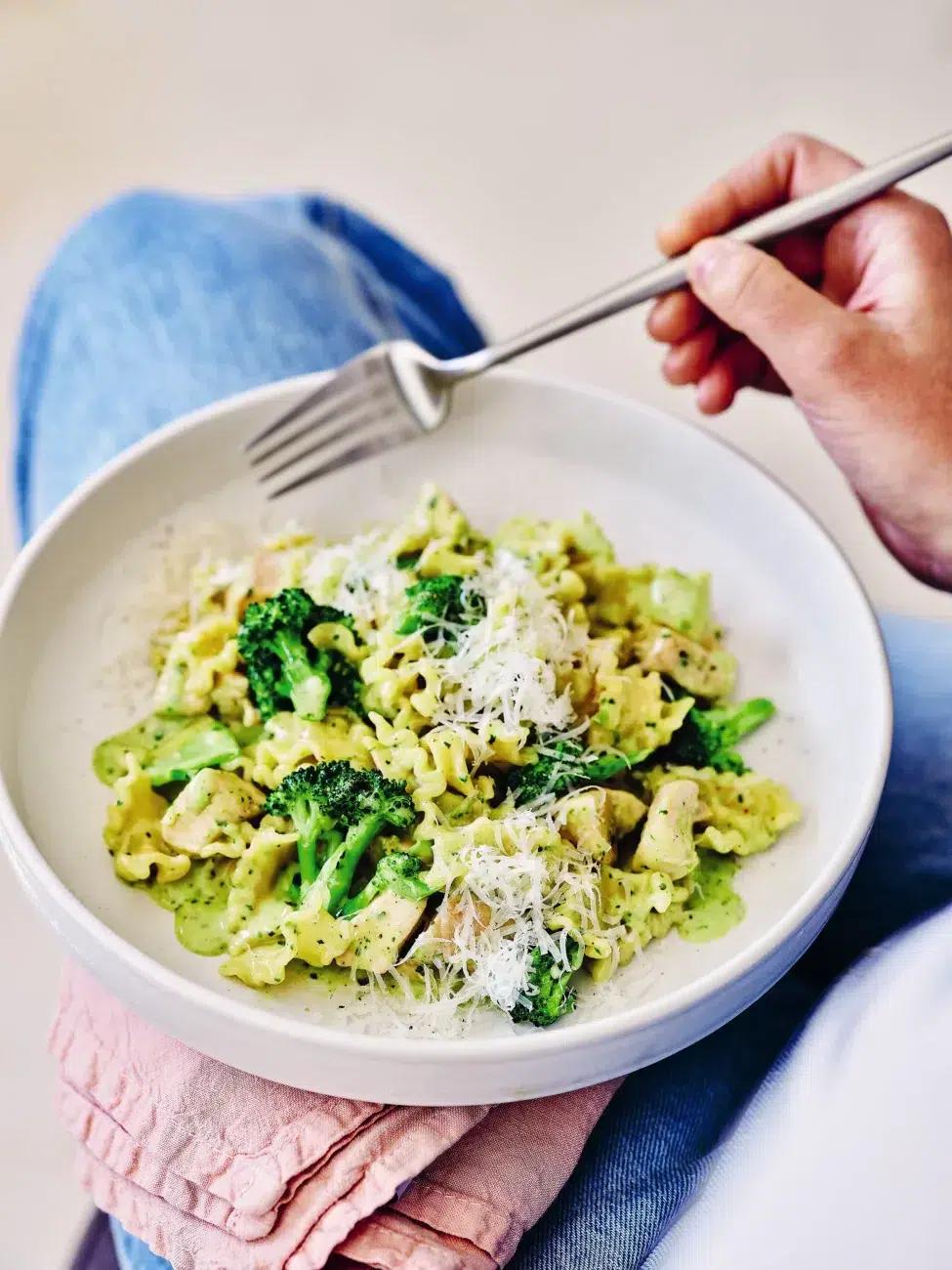family enjoying creamy pesto chicken dinner, smiling around a kitchen table