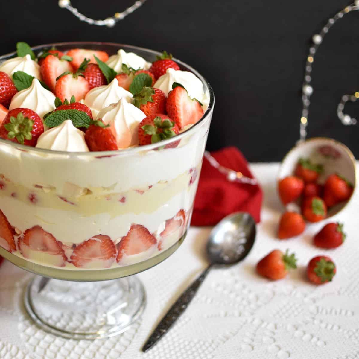 People serving and enjoying a slice of strawberry trifle during a gathering
