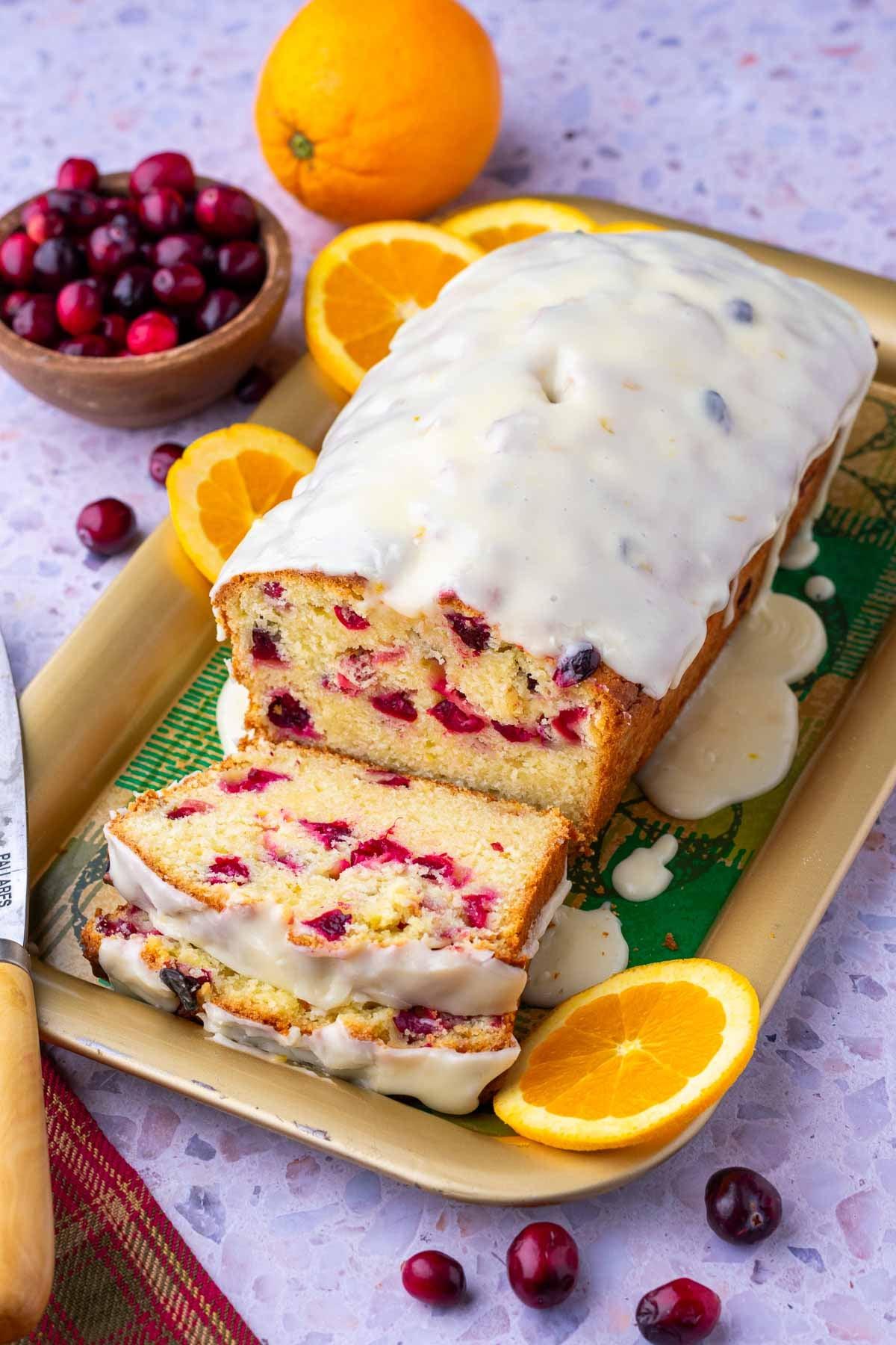 Whole cranberry orange bread on a cooling rack, steam gently rising