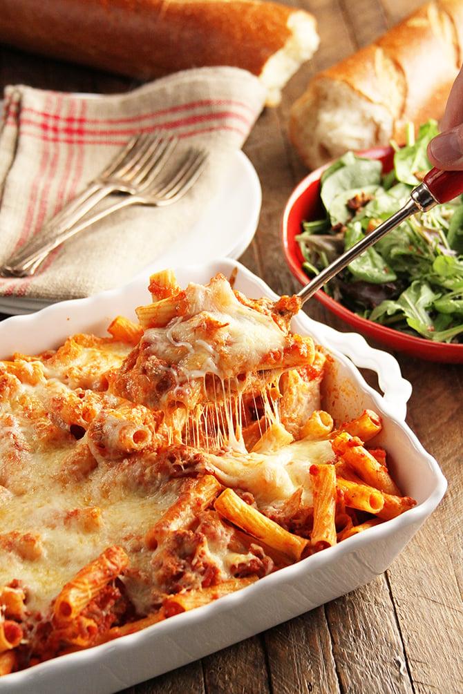 Hearty cheesy baked ziti casserole fresh from oven, with steam rising
