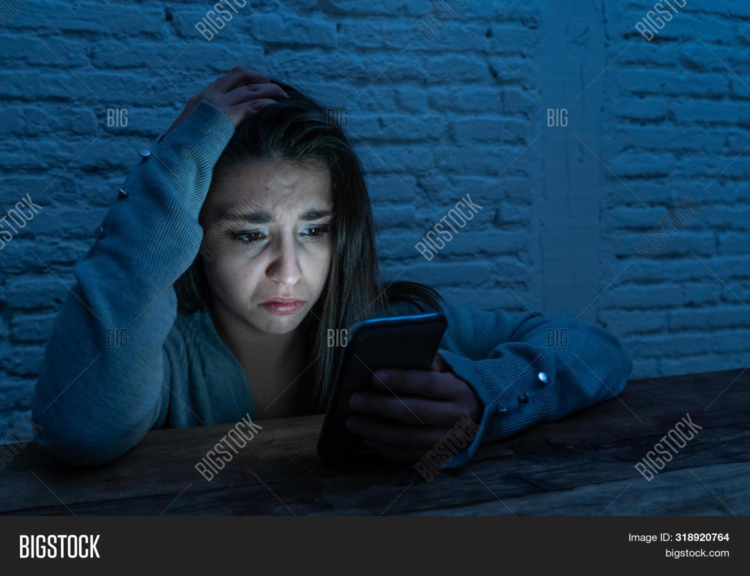 woman feeling sad while looking at her phone