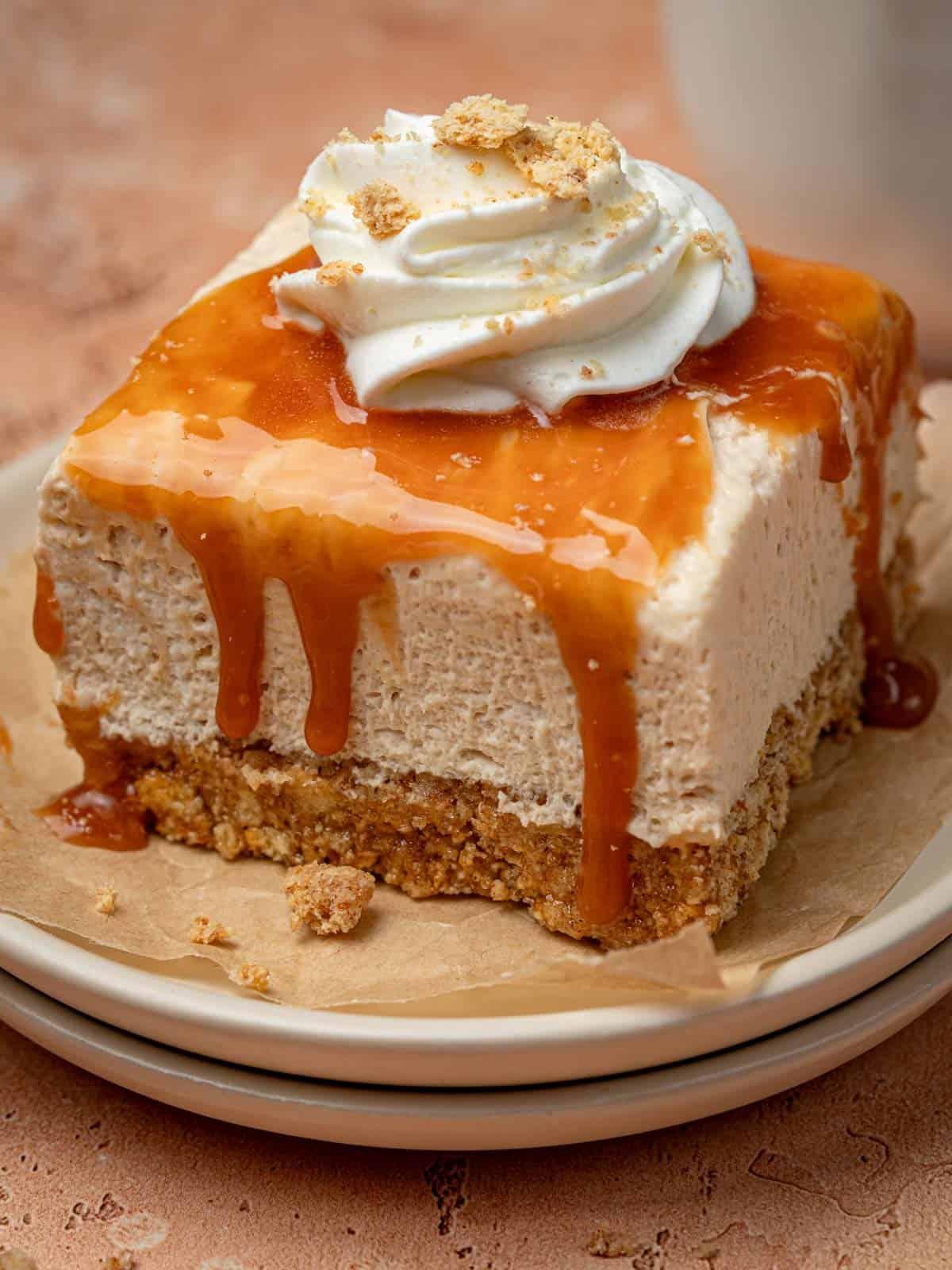 Homemade caramel sauce being drizzled over a chilled cheesecake
