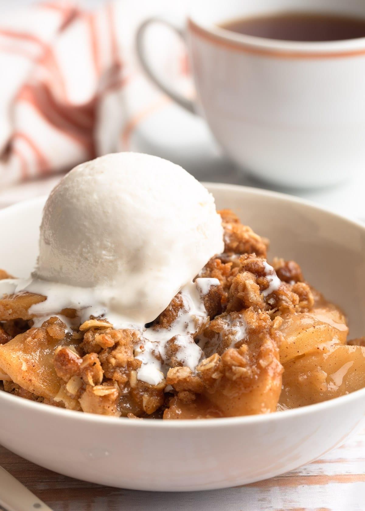 homemade apple crisp with a scoop of vanilla ice cream, cozy autumn setting, rustic background