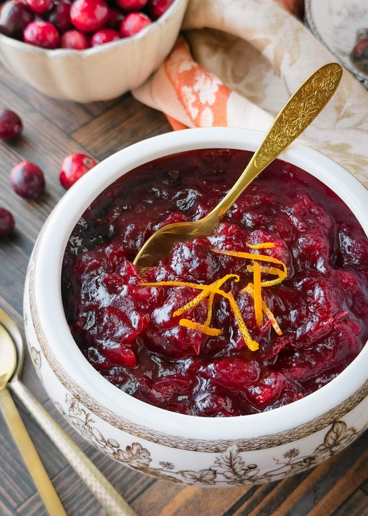Homemade cranberry sauce in a beautiful serving bowl with a ladle