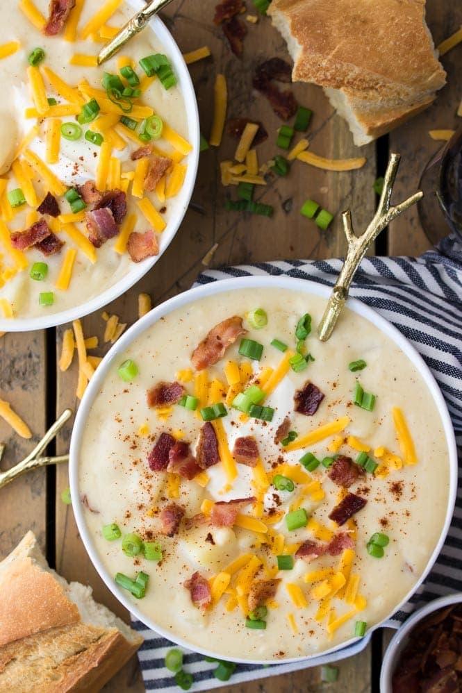 Overhead shot of creamy potato soup in bowls with various toppings