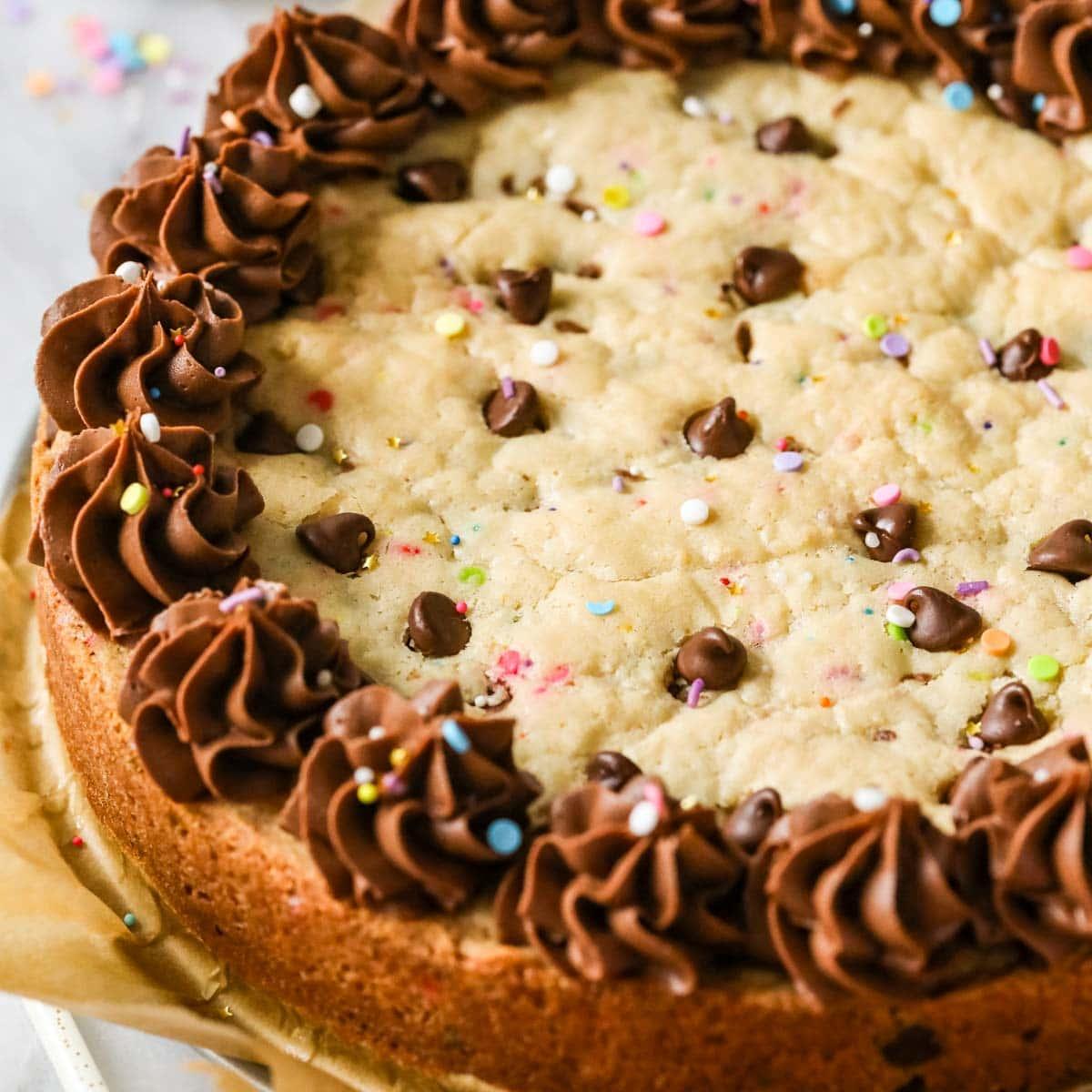 various cookie cakes with different frosting colors and toppings, showcasing the versatility of the dessert