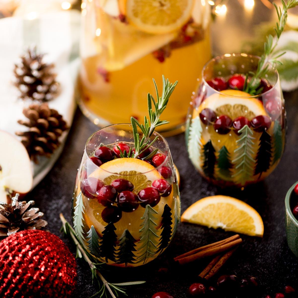 festive ruby sangria pitcher with fruit and holiday decorations, close-up, warm lighting