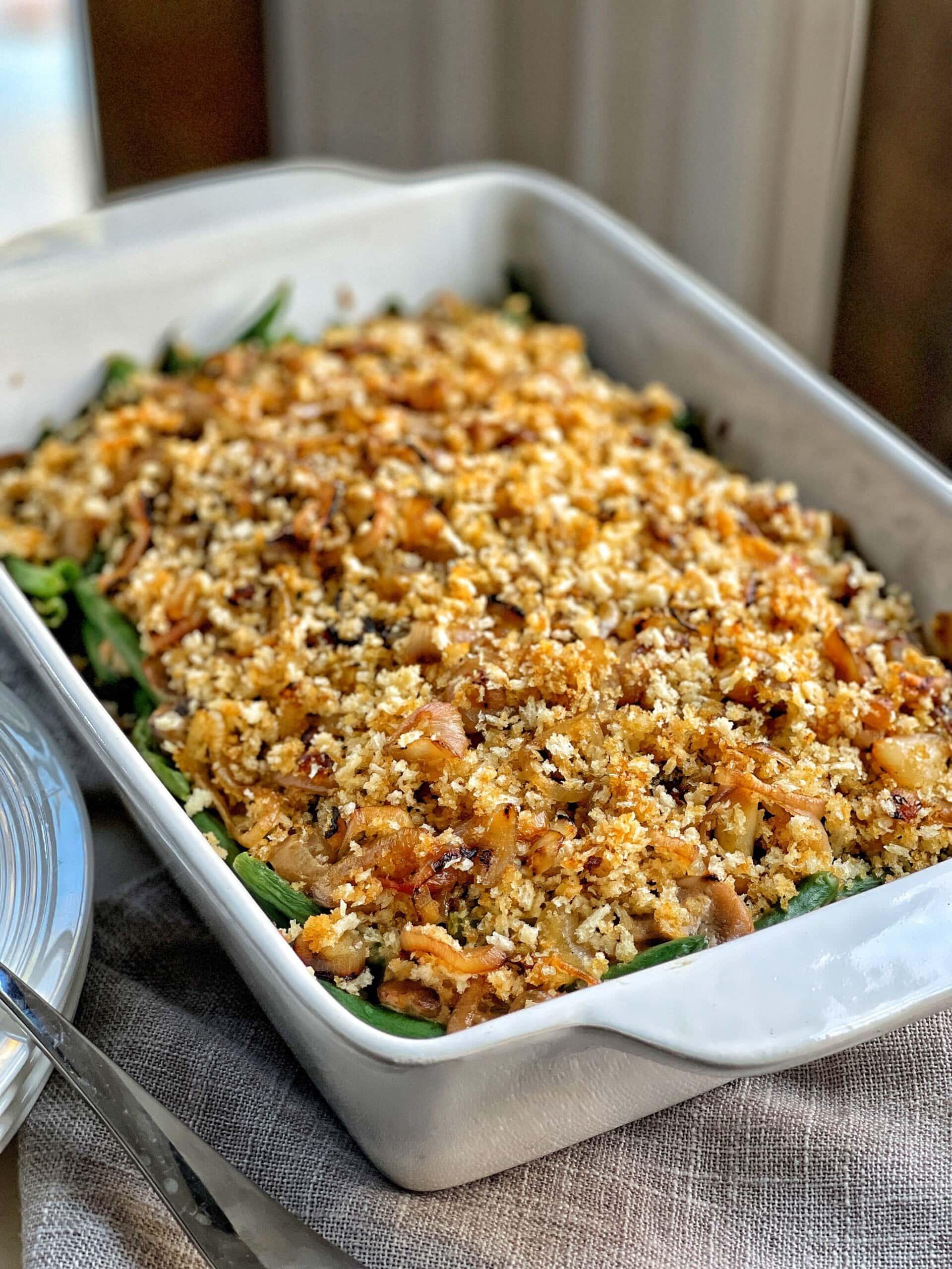 Close-up of a homemade green bean casserole with a golden brown crumb topping