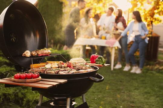person grilling outdoors with friends