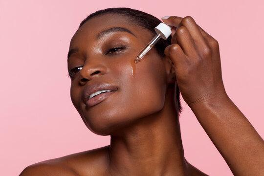 woman applying serum to her face
