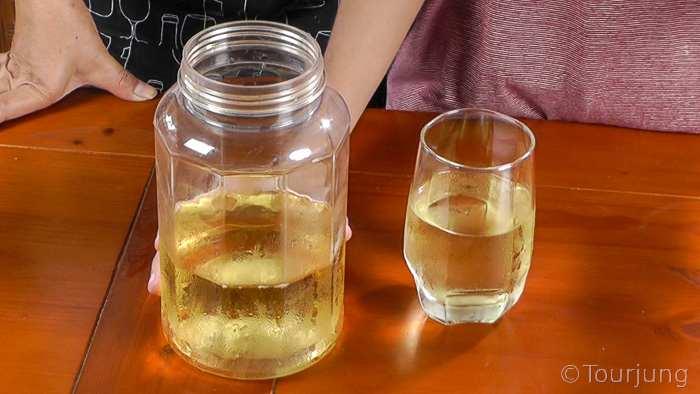 close up of jasmine green tea leaves steeping in cold water in a glass jar