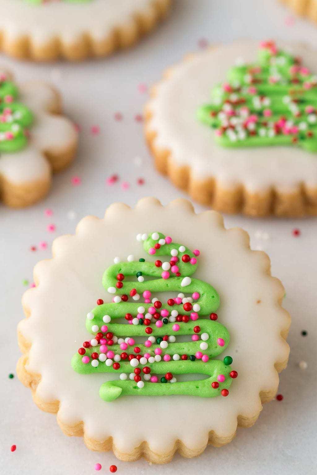 Beautifully decorated shortbread cookies with intricate icing designs on a rustic wooden table, natural light