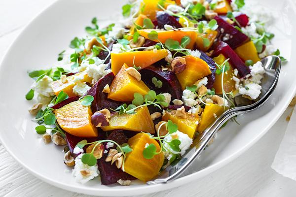 Person enjoying a vibrant roasted beet salad at a cozy restaurant