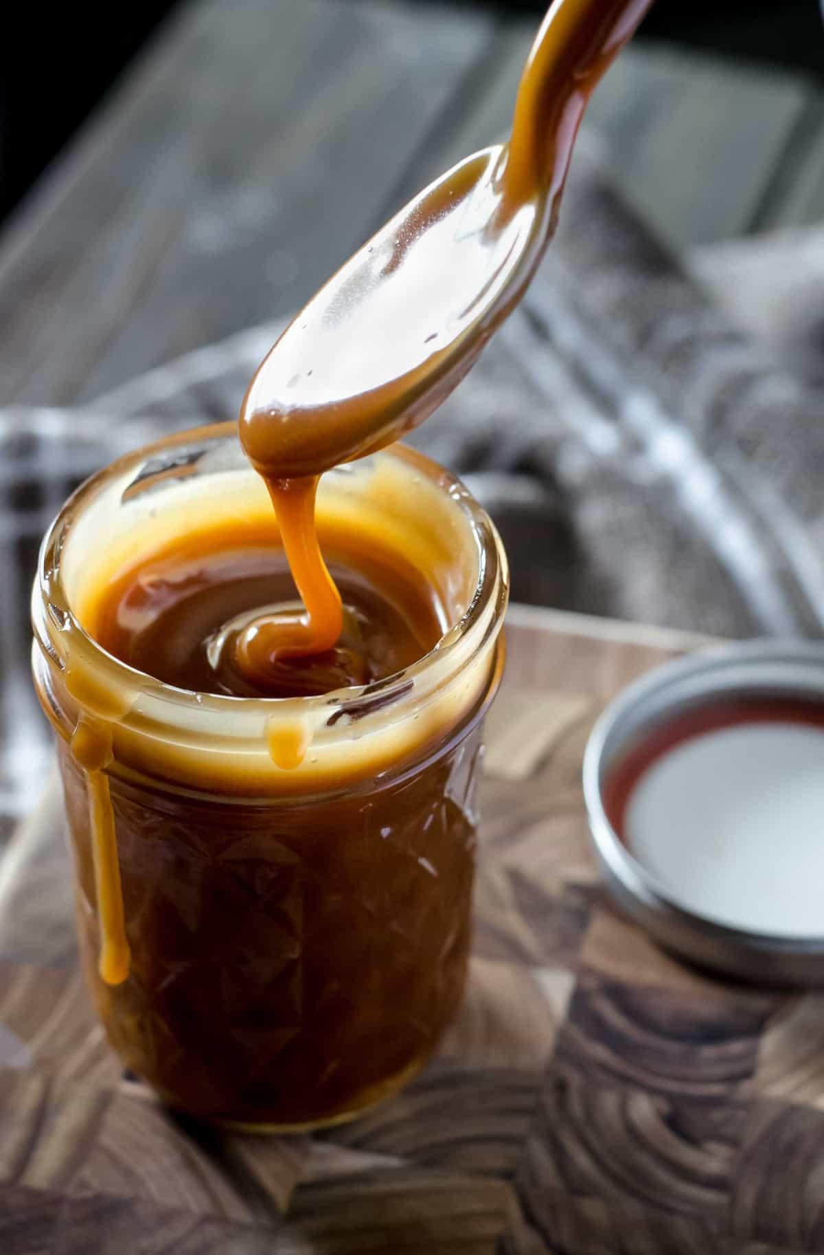 Close-up of golden homemade caramel sauce drizzling over a spoon