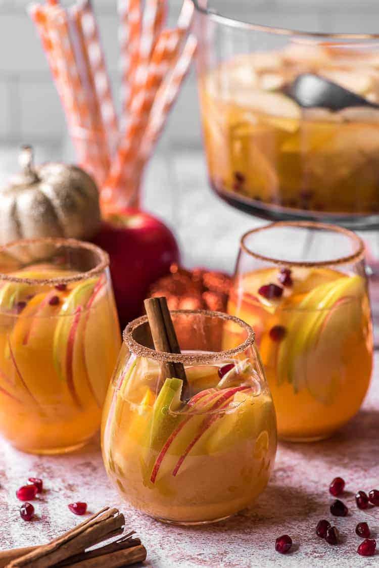 Close-up of a glass of pumpkin punch garnished with cinnamon sticks and apple slices