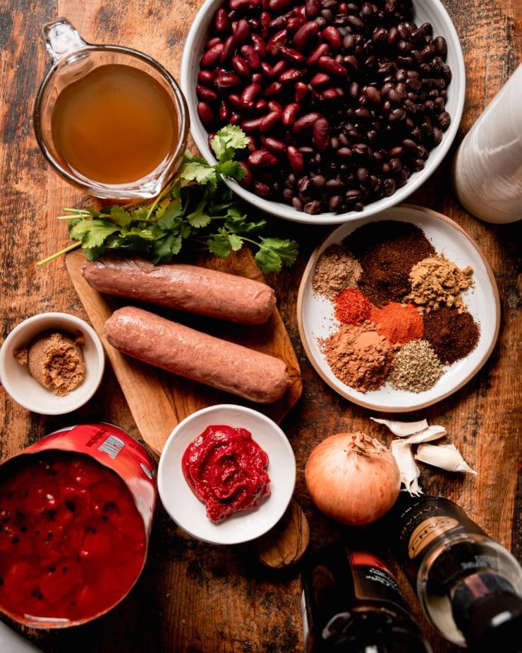 ingredients for vegan chili arranged on a wooden table