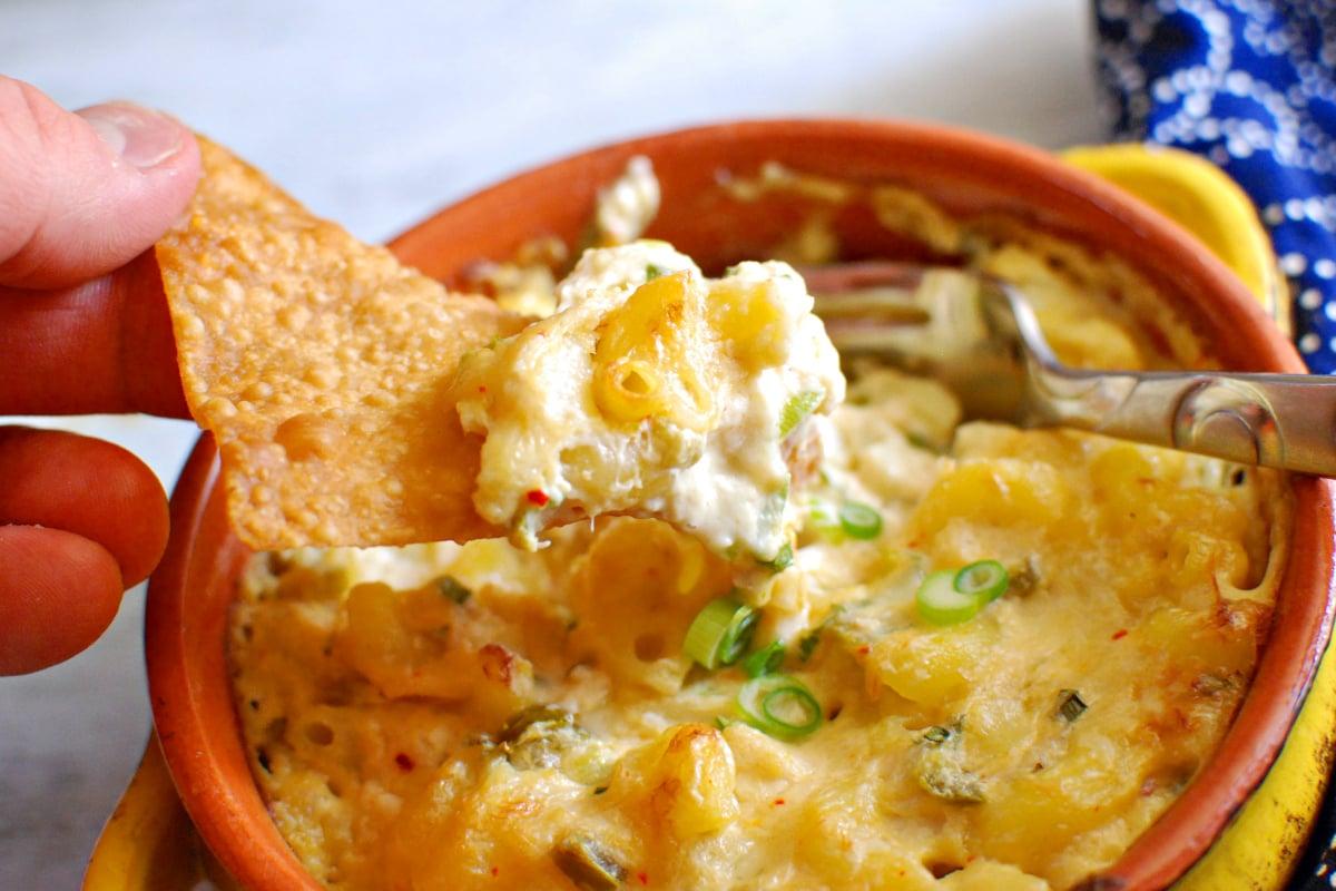 close up shot of creamy crab rangoon mac and cheese being spooned into a bowl
