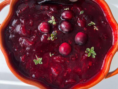 Grandmother and granddaughter making cranberry sauce together, joyful