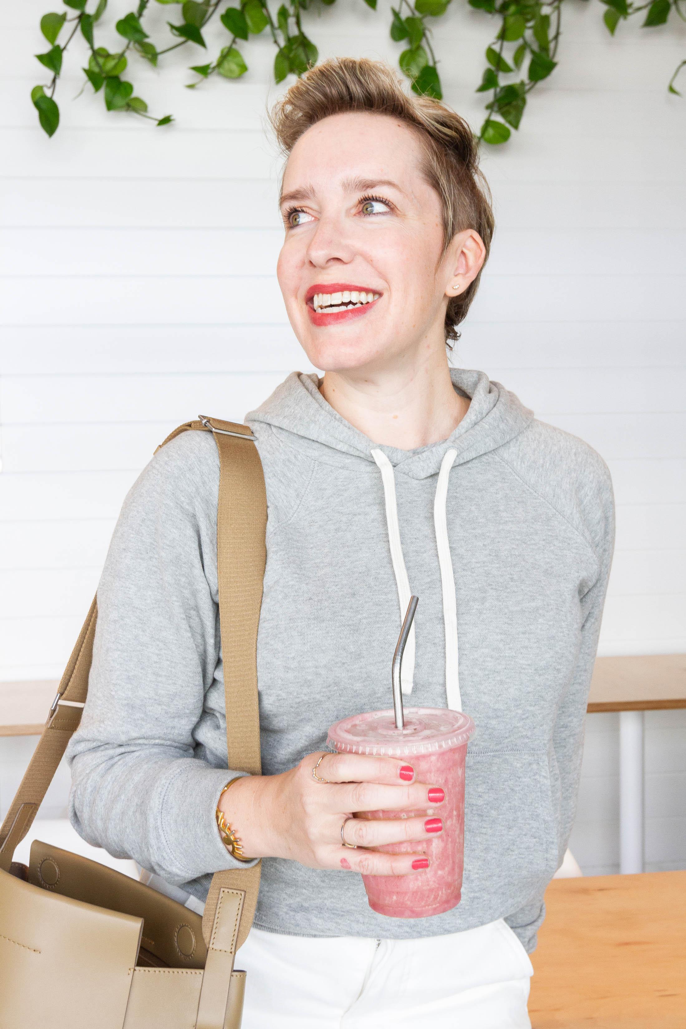 woman smiling and holding Everlane shopping bag