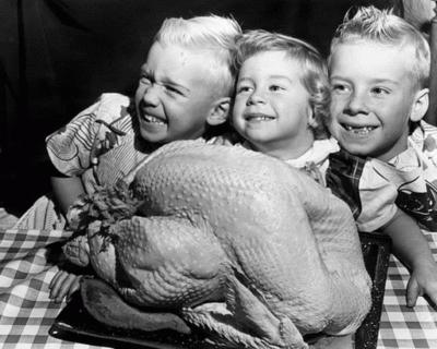 Vintage photo of a family enjoying Thanksgiving dinner with a prominent sweet potato casserole on the table, warm lighting