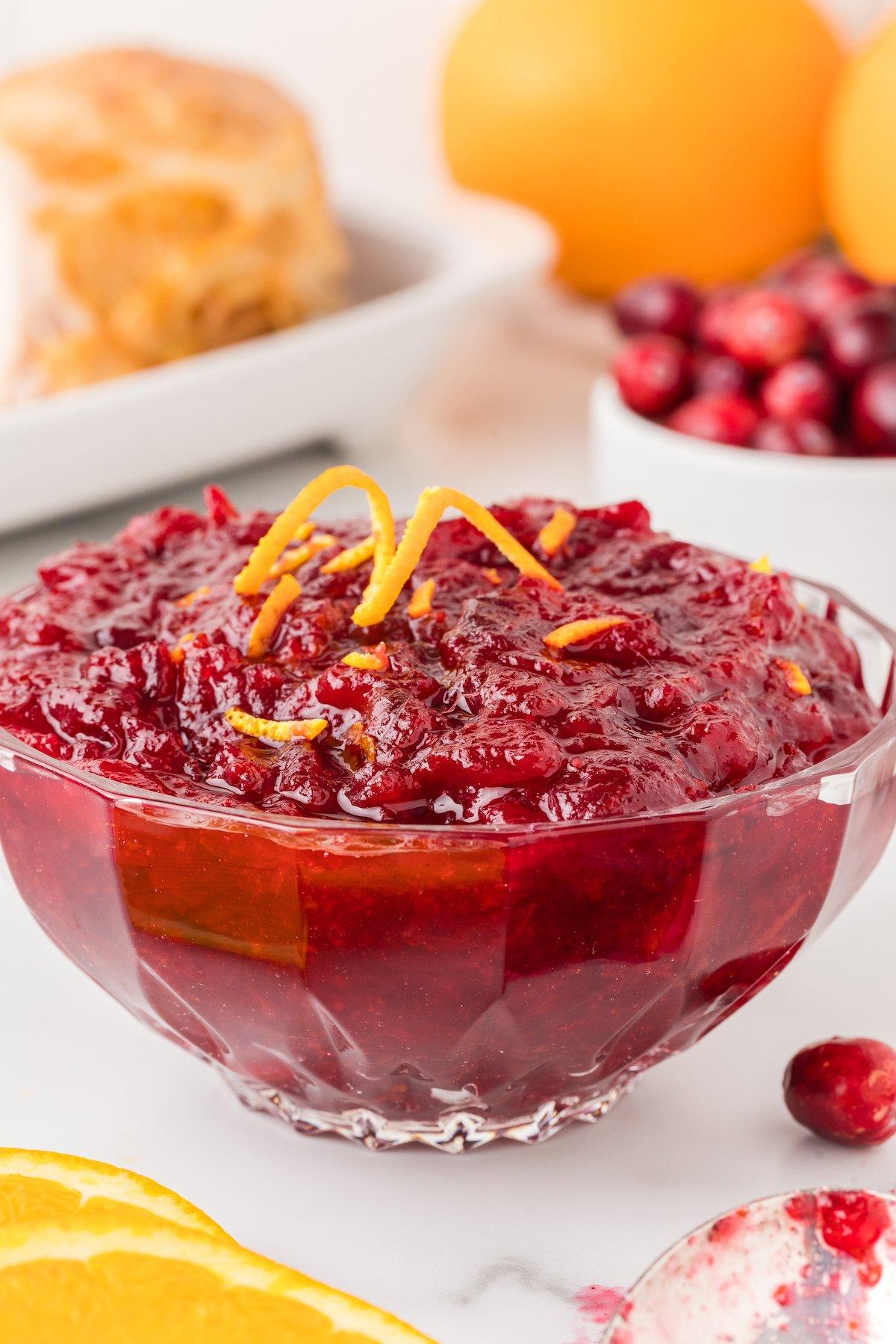 Close-up of fresh cranberries, orange zest, and sugar being prepared for sauce