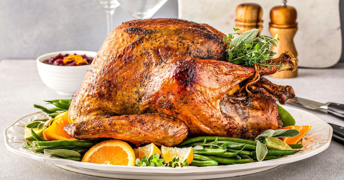 Golden brown roasted turkey with fresh herbs, carving knife ready