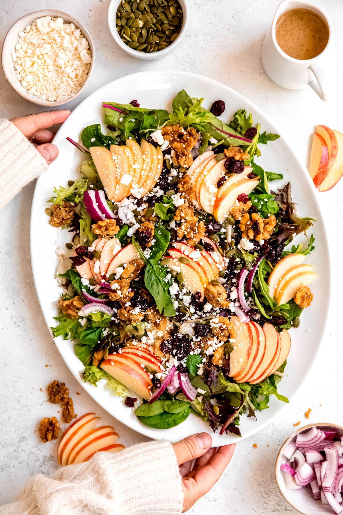 Vibrant apple walnut salad with honey drizzle in a wooden bowl