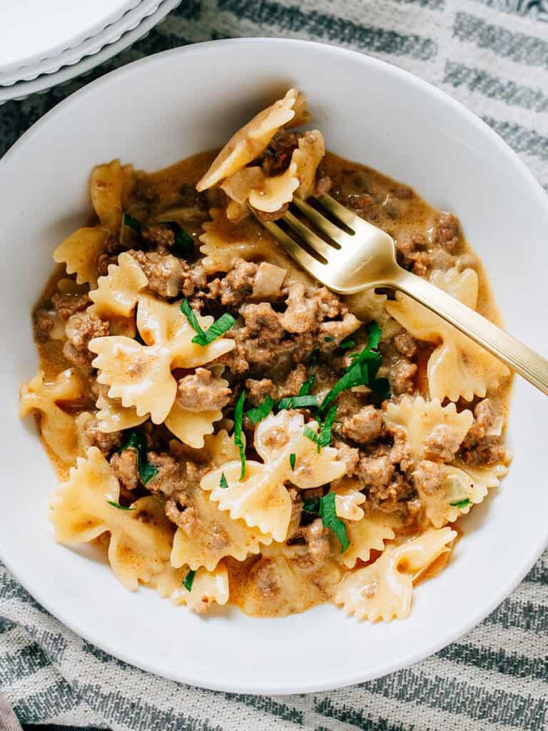hearty bowl of creamy ground beef pasta with fresh parsley garnish
