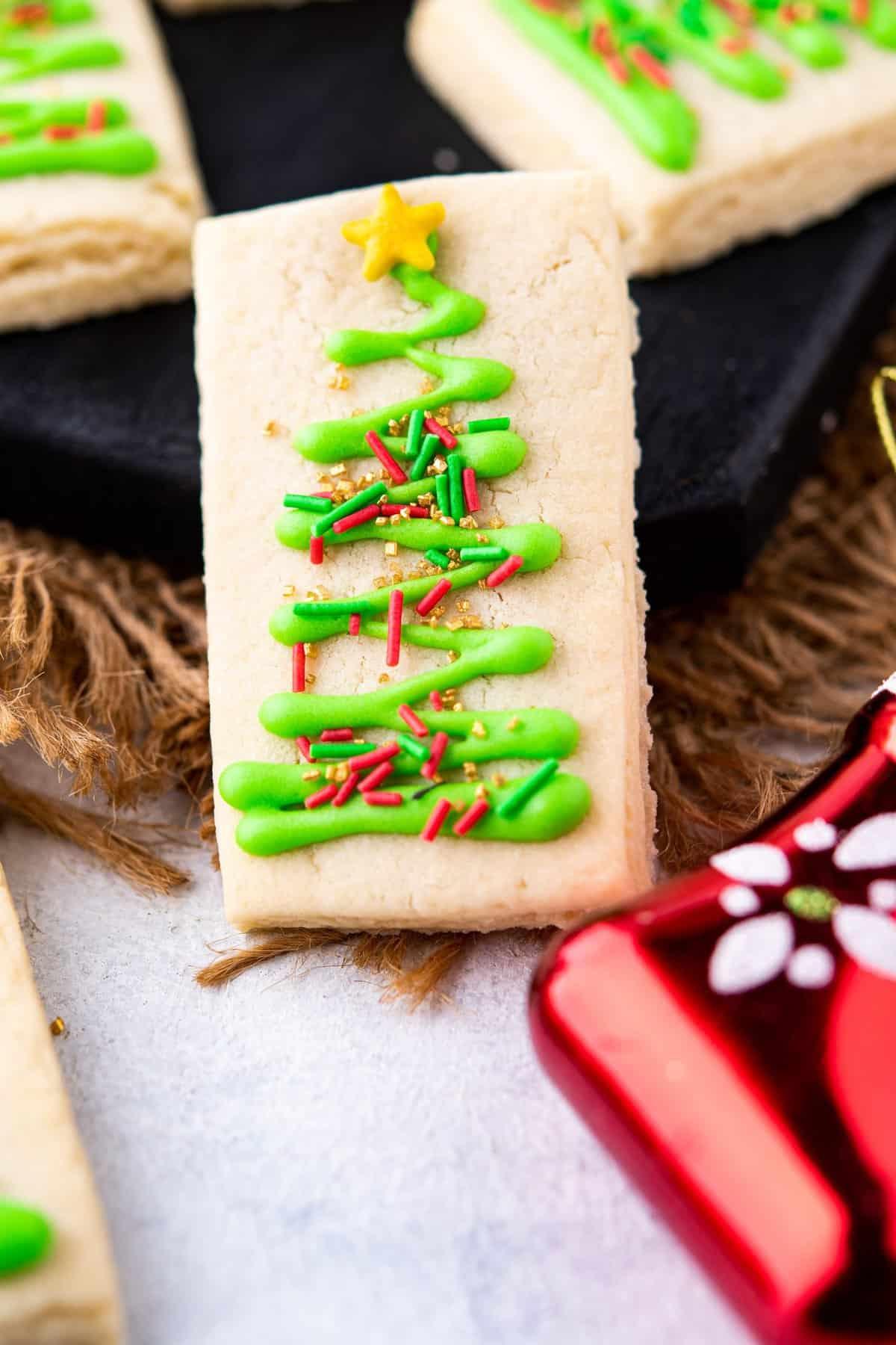 Close-up of a hand piping delicate royal icing onto a shortbread cookie