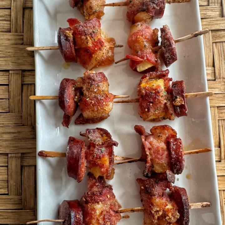 A completed bacon and pineapple skewer, ready to be served with sweet chili sauce
