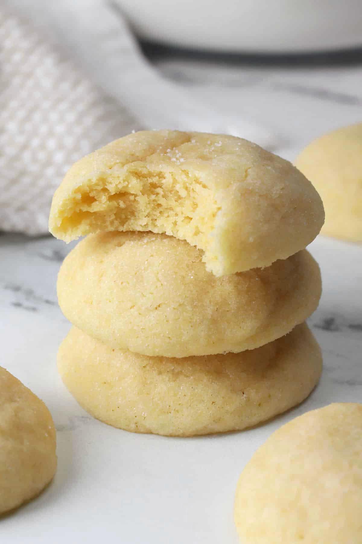 close-up photo of perfectly baked sugar cookies with powdered sugar, melting texture, warm kitchen light