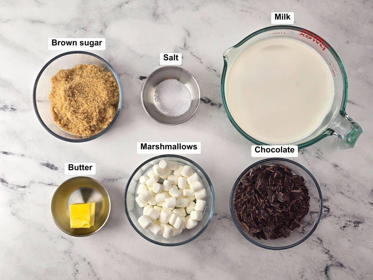 ingredients for salted caramel hot chocolate laid out on a kitchen counter: chocolate, cream, sugar, salt