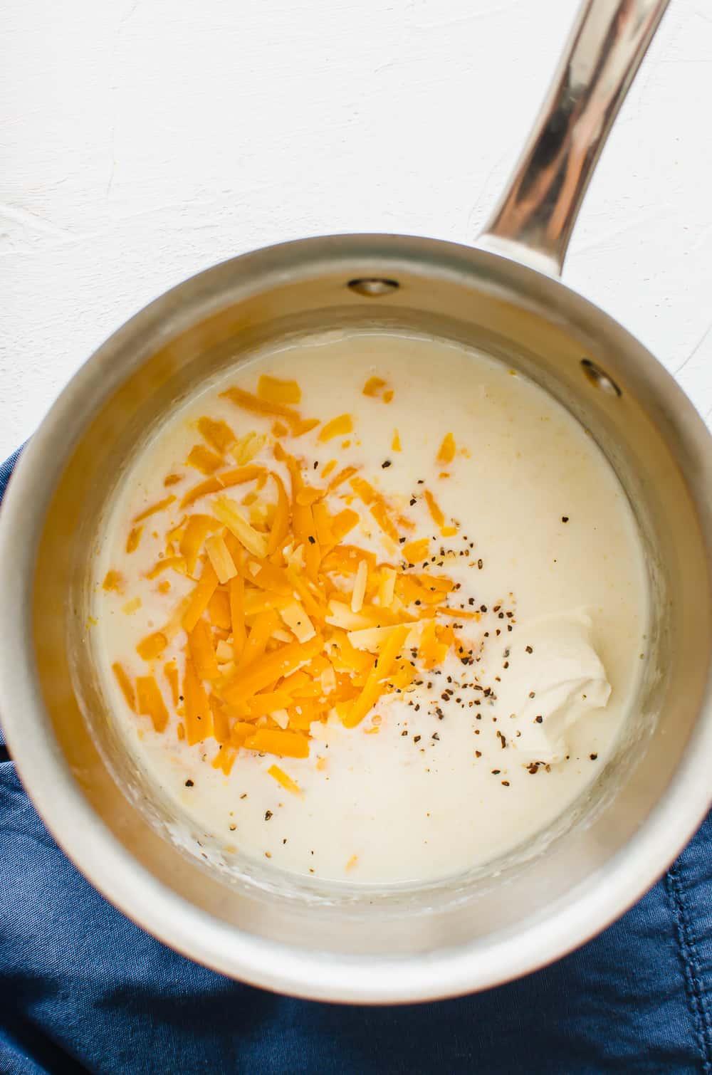 creamy cheese sauce being stirred in a saucepan, close-up with steam rising