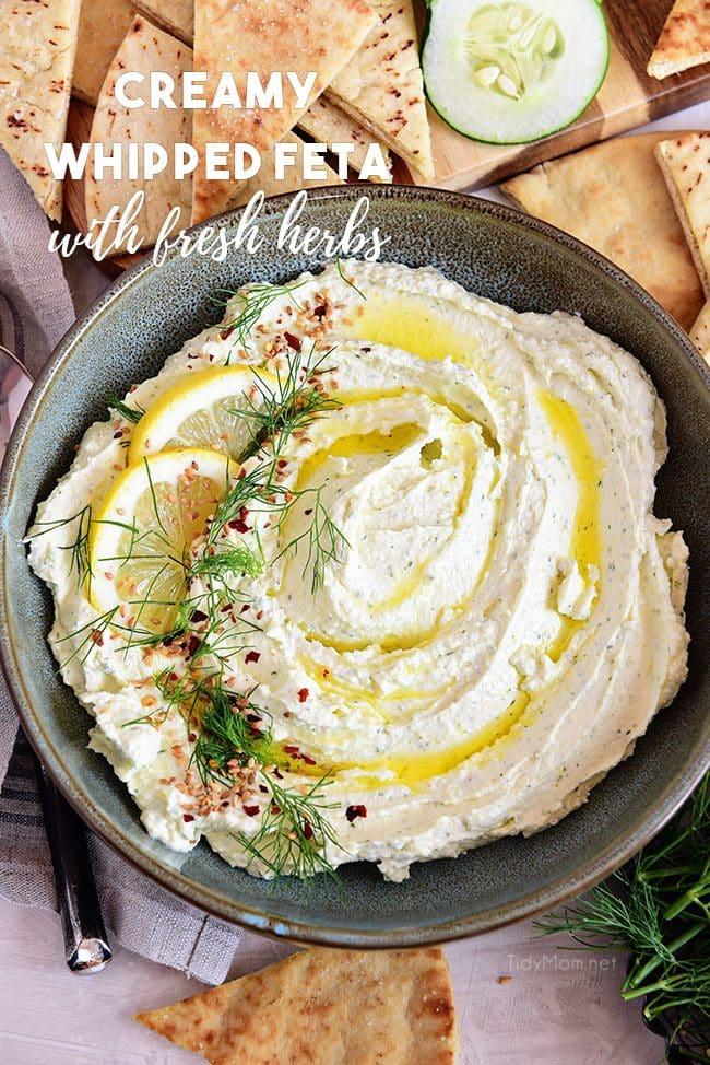 Close-up shot of a creamy white whipped feta dip in a stylish ceramic bowl, garnished with fresh herbs and a drizzle of olive oil